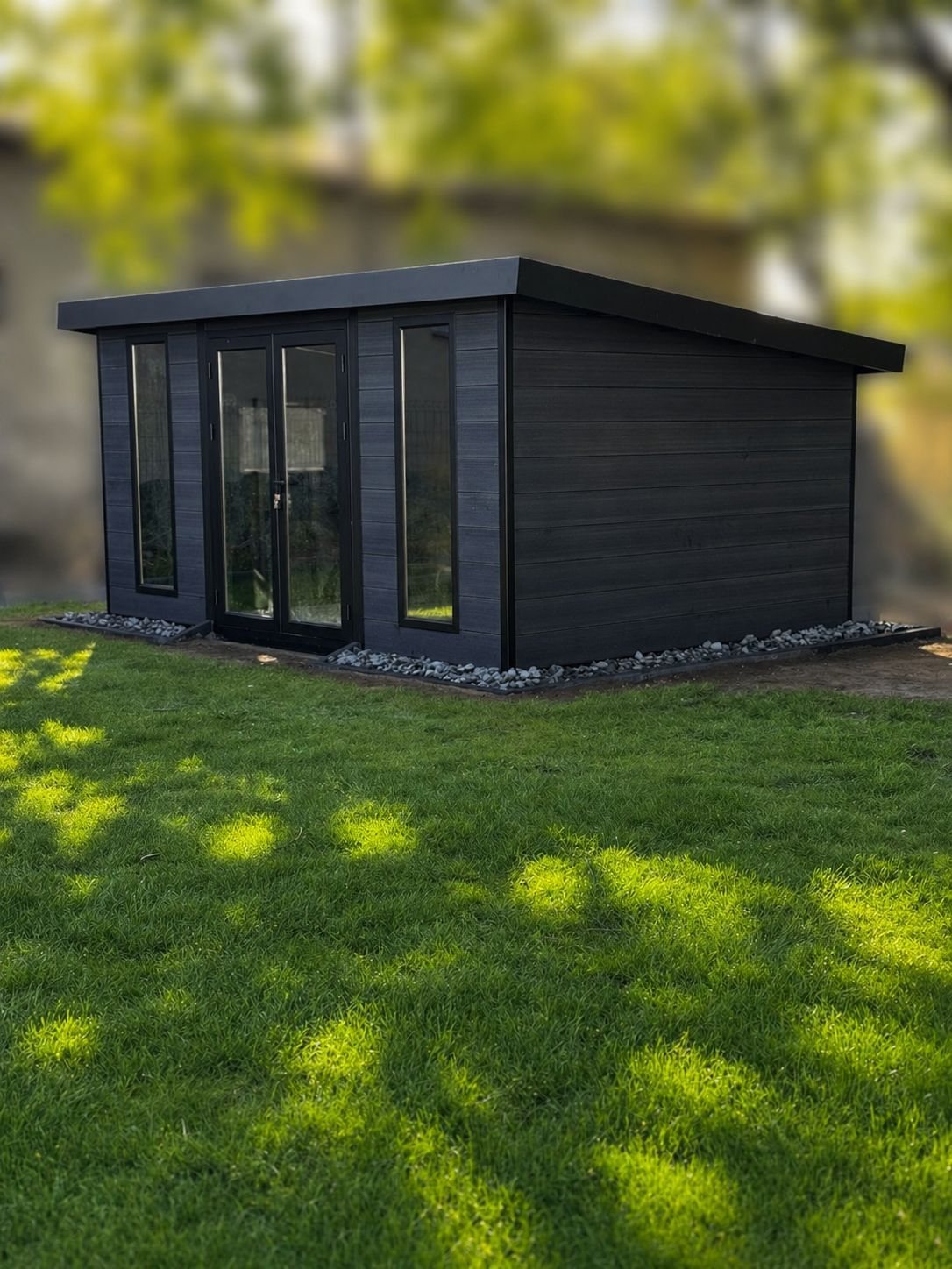 Echtes Kundenprojekt: frischer Rasen vor einem modernen anthrazitfarbenen Gartenhaus